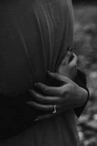 Close-up of hands holding cross against blurred background