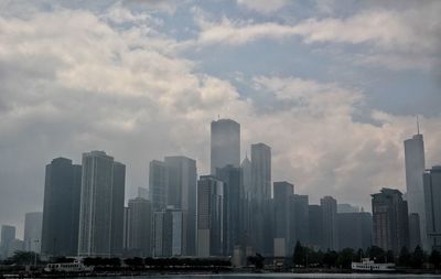 Buildings in city against cloudy sky