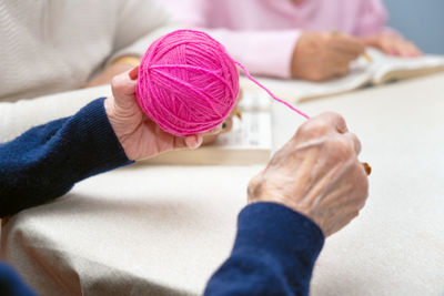 Cropped hand of woman holding sewing machine