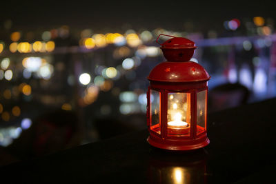 Close-up of illuminated lantern on table at night