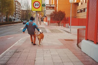 Full length of woman walking on sidewalk