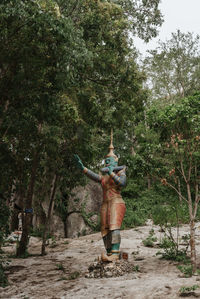 Rear view of man standing on dirt road