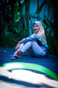 Portrait of smiling young woman sitting outdoors