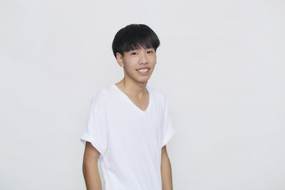 Portrait of smiling man standing against white background
