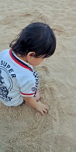 High angle view of cute girl on sand at beach