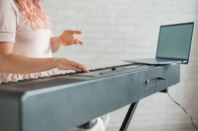 Midsection of woman using laptop on table