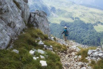 Woman walking on rocks against mountains