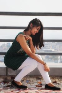 Woman sitting on railing