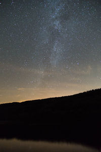 Scenic view of silhouette landscape against star field at night