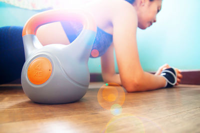 Close-up of kettlebell with woman exercising in background