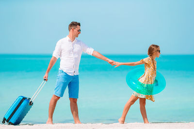 Couple kissing on beach against sea