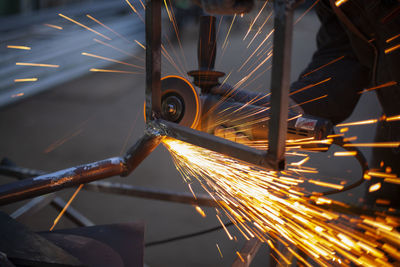 Sparks fly in all directions. cutting metal with a grinder. working in a metal workshop.