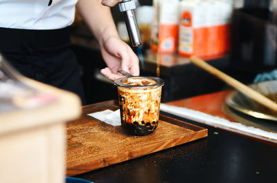 Midsection of chef preparing coffee on table