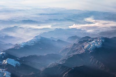 Aerial view of snowcapped mountains against sky