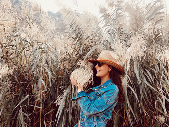 Young woman wearing hat standing on field