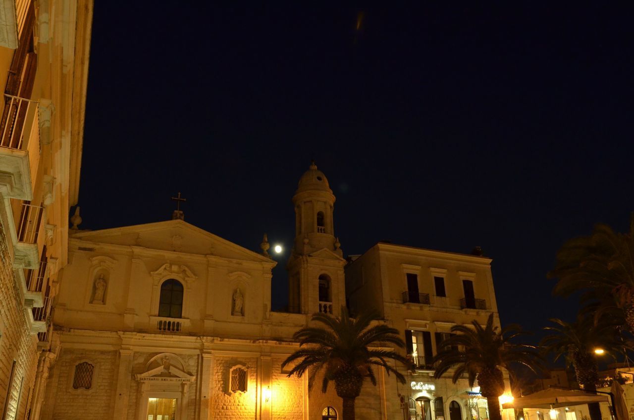 LOW ANGLE VIEW OF ILLUMINATED BUILDINGS AGAINST SKY AT NIGHT