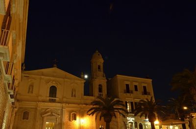 Low angle view of illuminated building against sky at night