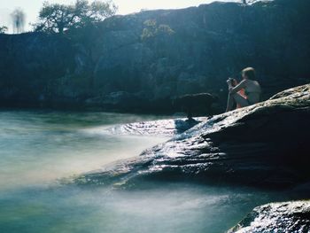 People on rocks by sea