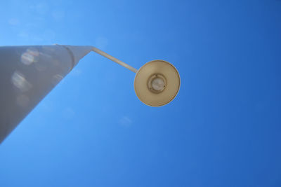 Low angle view of lighting equipment against clear blue sky