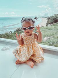 Portrait of baby girl wearing sunglasses sitting outdoors