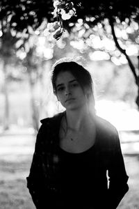 Portrait of young woman standing at park