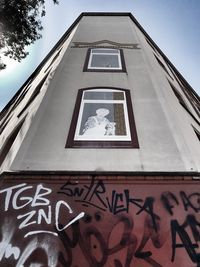 Low angle view of text on building against sky