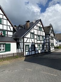 Houses by street against sky in city