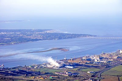 High angle view of town by sea against sky