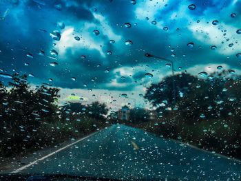 Road seen through wet glass window