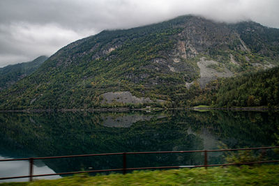 Scenic view of lake by mountains against sky