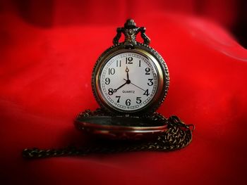 Close-up of clock on red table