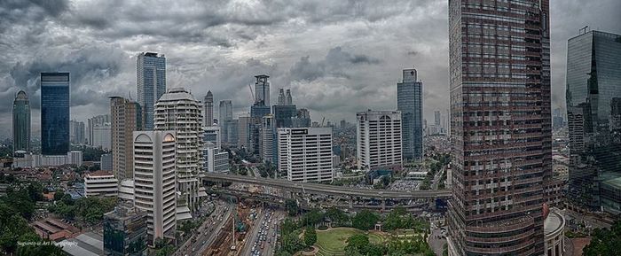 Skyscrapers against cloudy sky