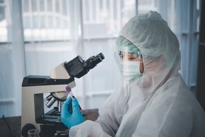 Close-up of doctor examining over microscope