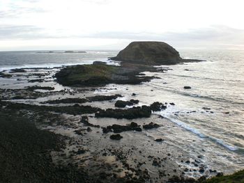 Rocks on beach against sky