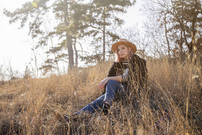 Portrait of young woman in hat on field