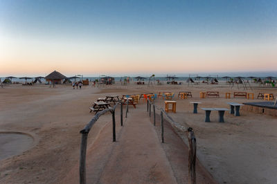 People at beach against clear sky