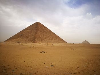 View of desert against cloudy sky