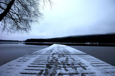 Surface level of frozen lake against sky during winter