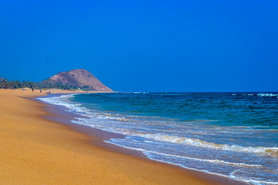 Scenic view of beach against clear blue sky