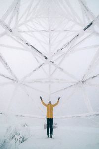 Rear view of man holding umbrella