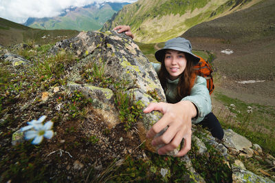 Rear view of woman sitting on rock