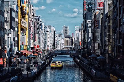 Canal amidst buildings in city against sky