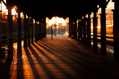 Illuminated street amidst buildings at sunset