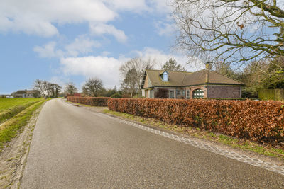 Road amidst trees against sky