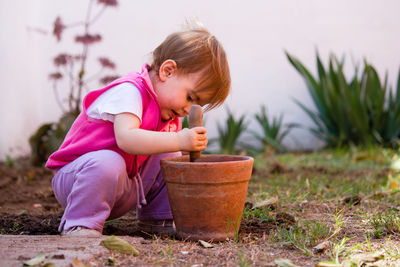 Cute girl playing on plant