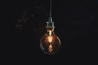 Close-up of illuminated bulb in darkroom