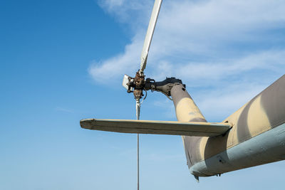 Helicopter rotor blades against a clear blue sky during a sunny day