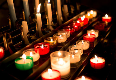 Lit tea light candles on table in church