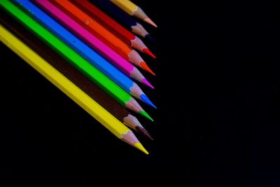 High angle view of colored pencils against black background