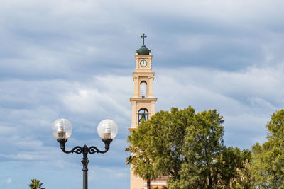 Low angle view of clock tower by building against sky
